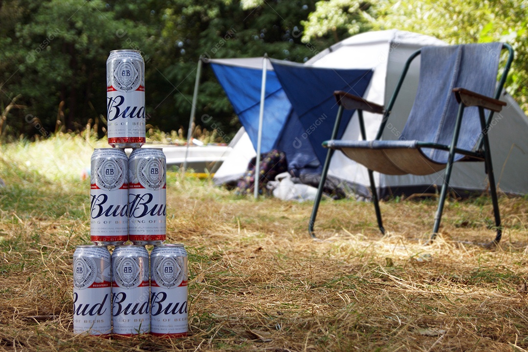 Latas de budweiser empilhadas sobre fundo de natureza