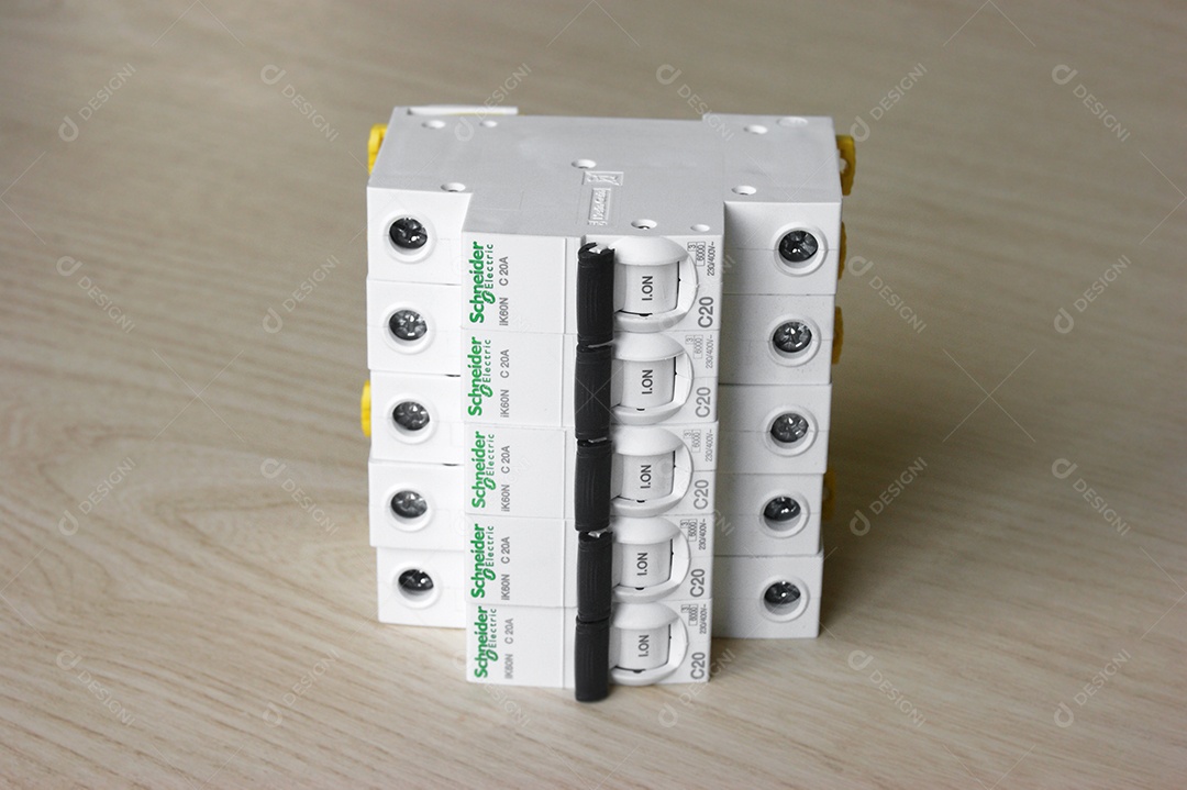 Disjuntores elétricos Schneider em fundo de madeira clara