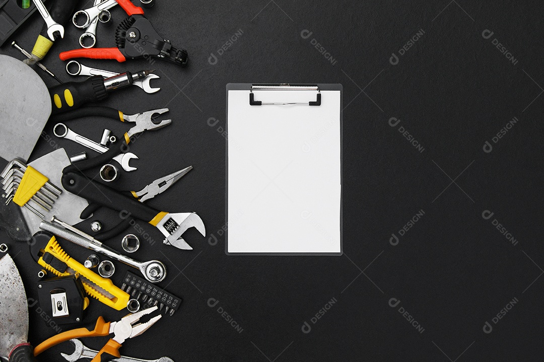 Prancheta de anotação e muitas ferramentas sobre fundo preto