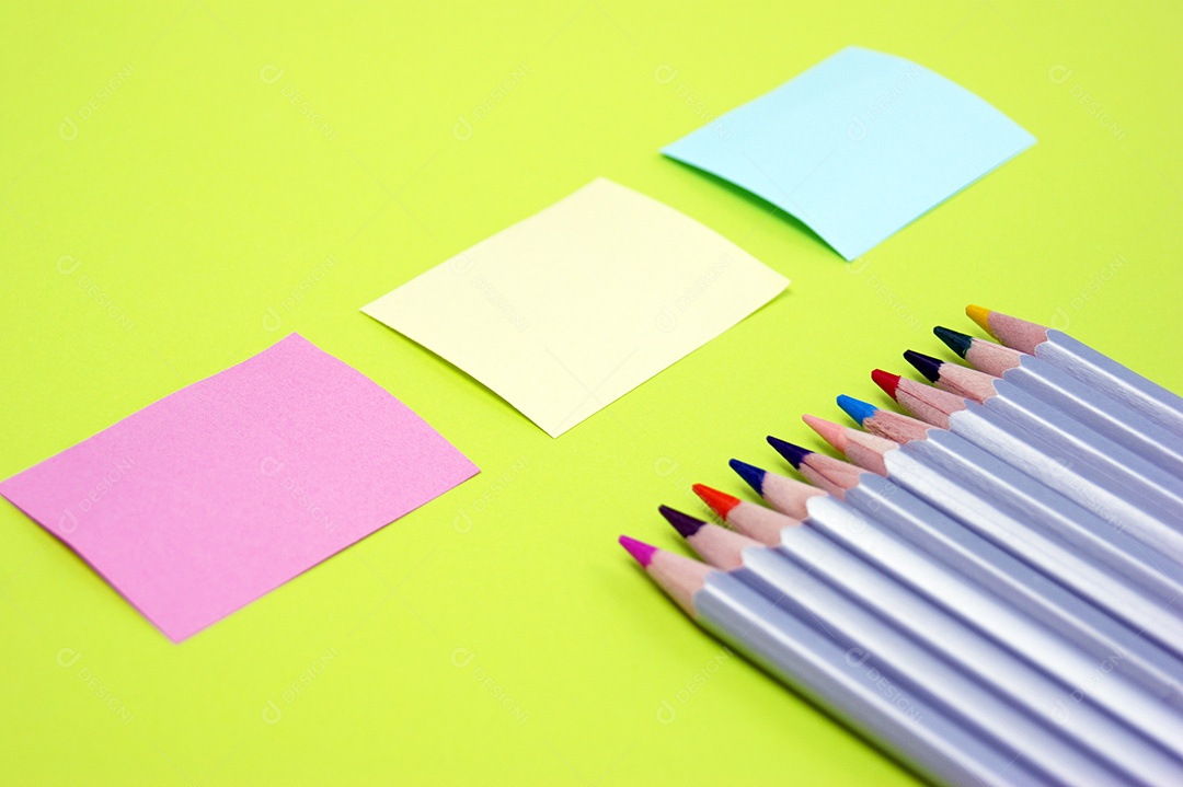 Três adesivos em branco e lápis coloridos. Lugar para texto. Copie o espaço.