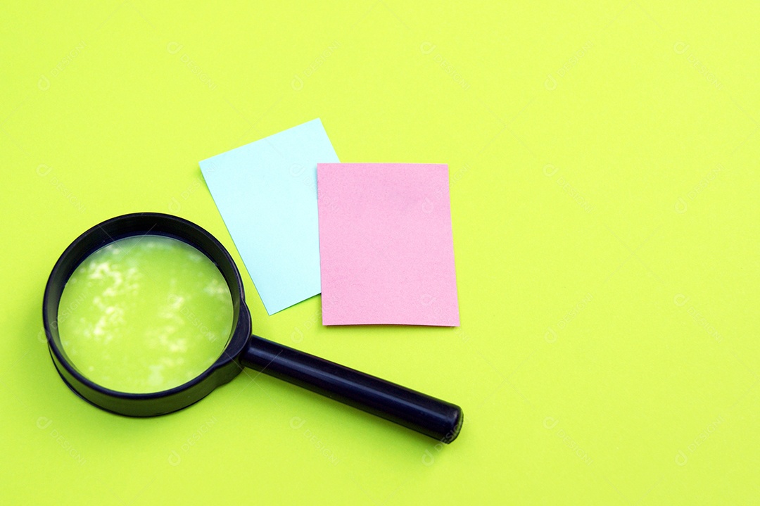Post it coloridos e uma lupa em fundo amarelo
