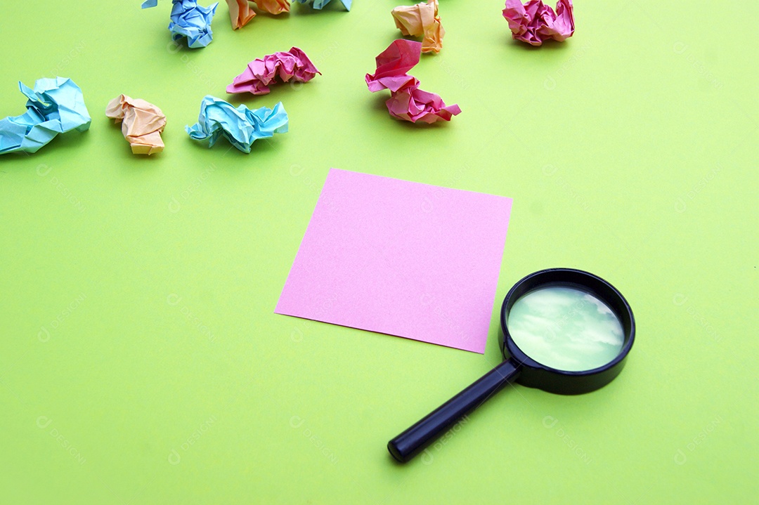 Lupa e papel colorido amassado