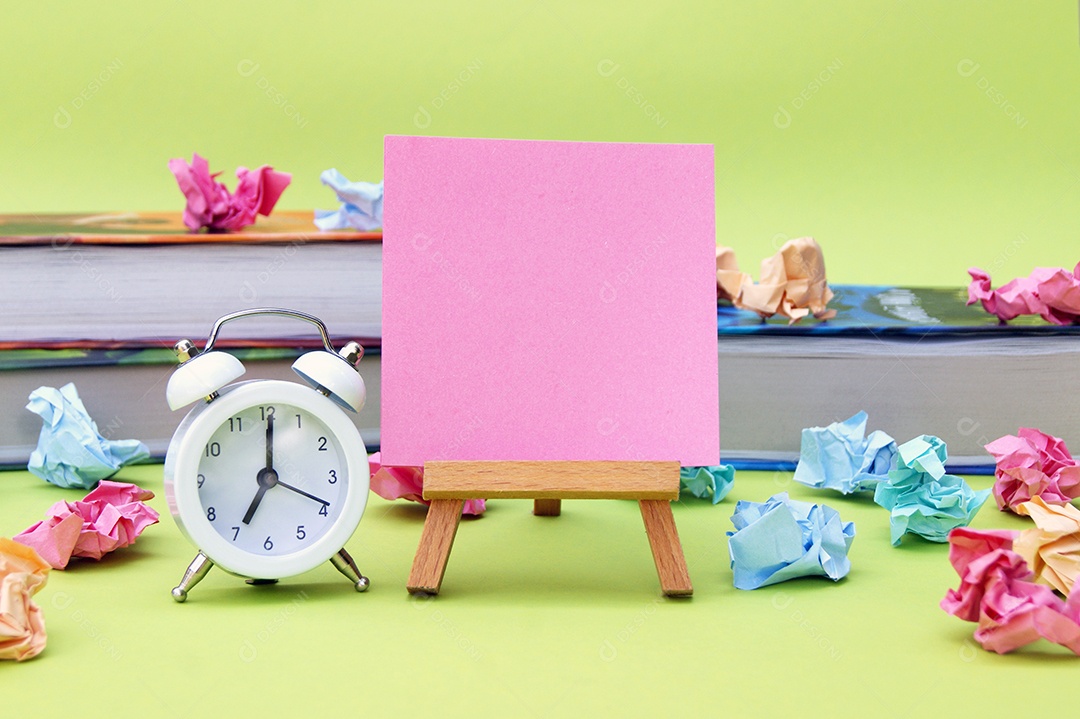 Cavalete com adesivo um despertador e materiais escolar conceito de volta as aulas