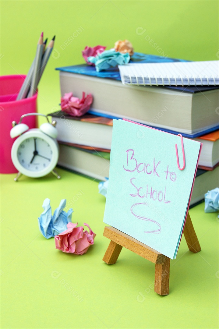 Livros caderno lápis e despertador conceito de volta as aula