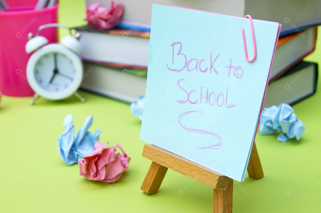 Pequeno cavalete com adesivo com a inscrição Volta às Aulas