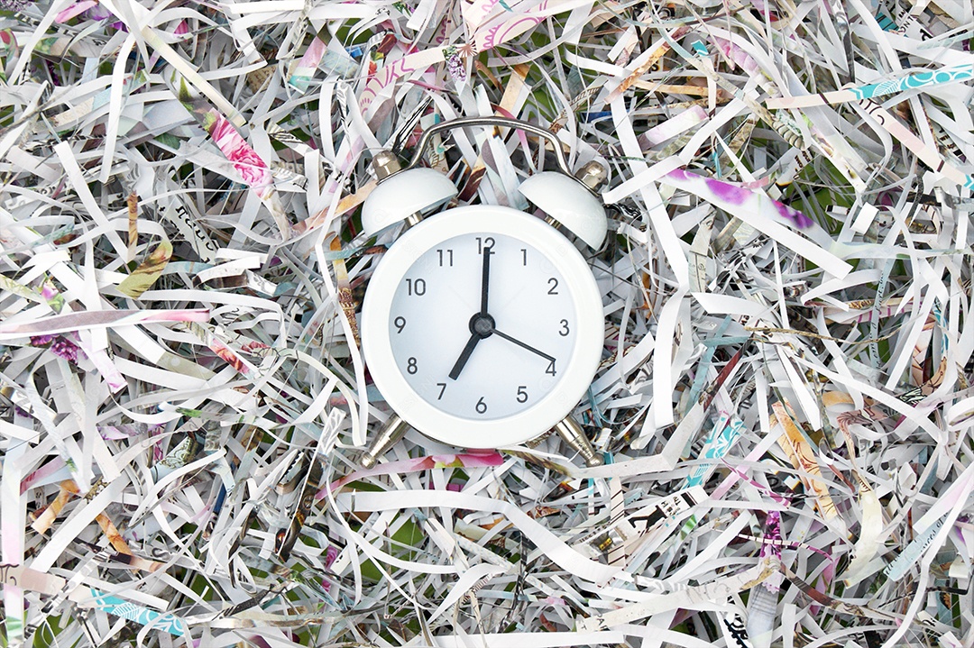 Despertador branco vintage em um fundo de papel picado
