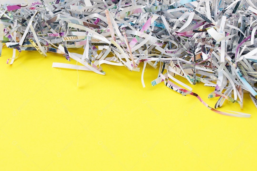 Papel cortados e picados sobre fundo amarelo