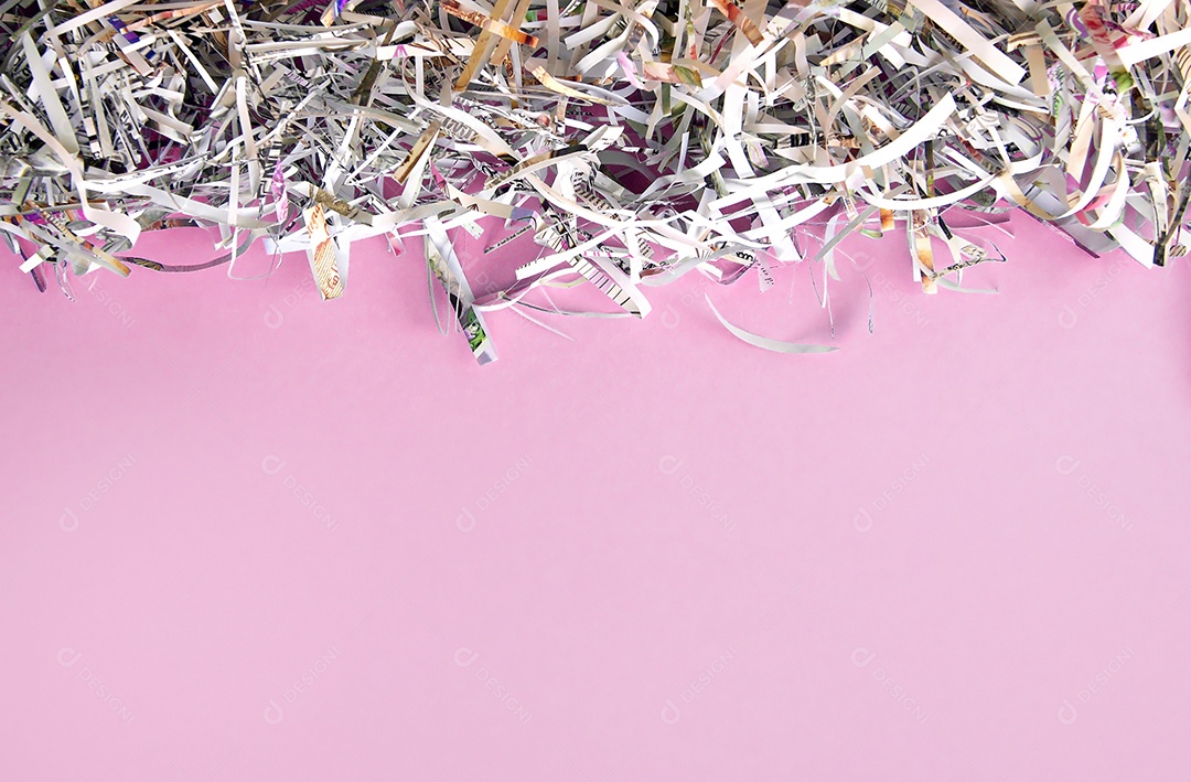Papel cortados e picados sobre fundo rosa