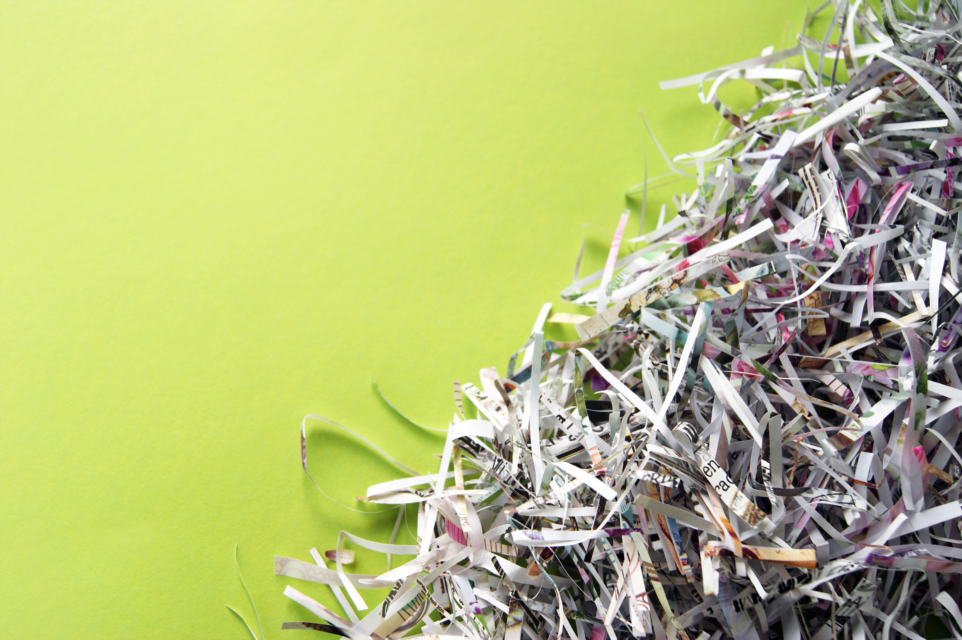 Papéis picados e embolados sobre fundo verde