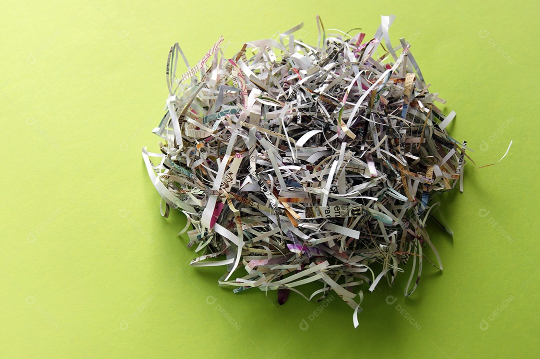 Papéis picados e embolados sobre fundo verde