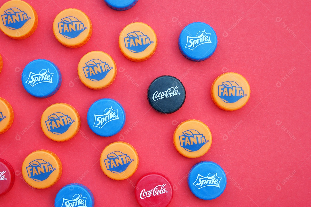 Tampas de refrigerantes diferente sobre fundo vermelho