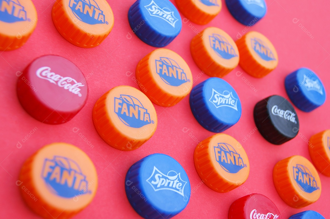 Tampas de refrigerantes diferente sobre fundo vermelho