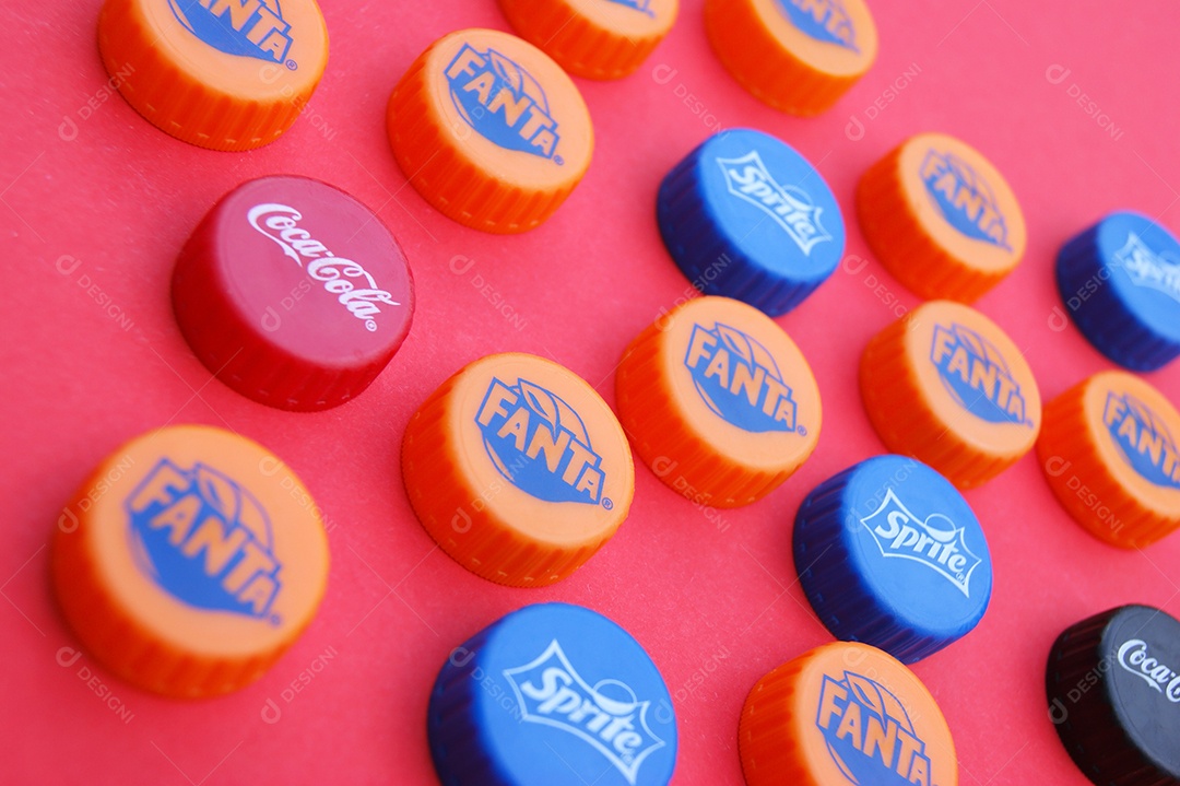 Várias tampas de garrafa pet sobre fundo vermelho