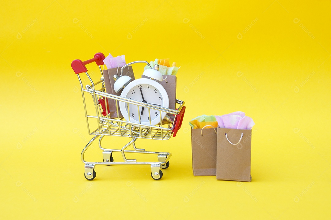 Carrinho de compra com relógio sacolas de presentes sobre fundo amarelo