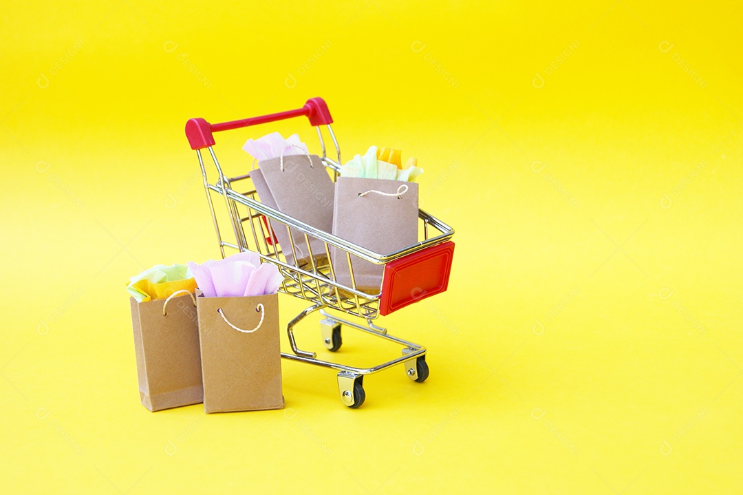 Carrinho cheio de sacolas de compras sobre fundo amarelo