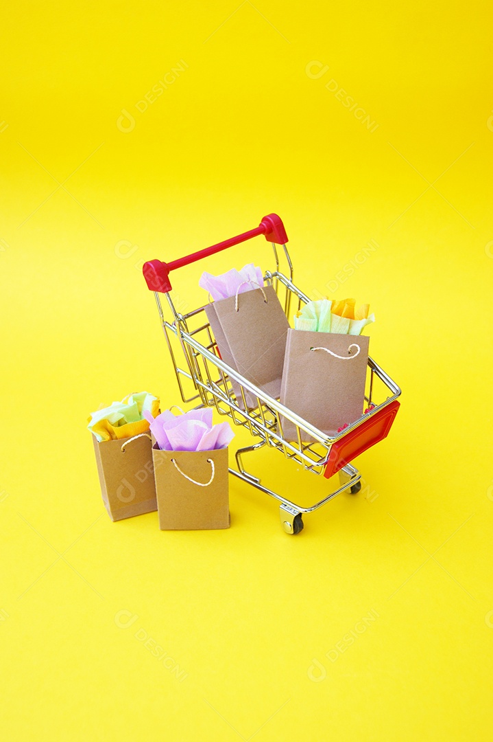 Carrinho cheio de compras sobre fundo amarelo