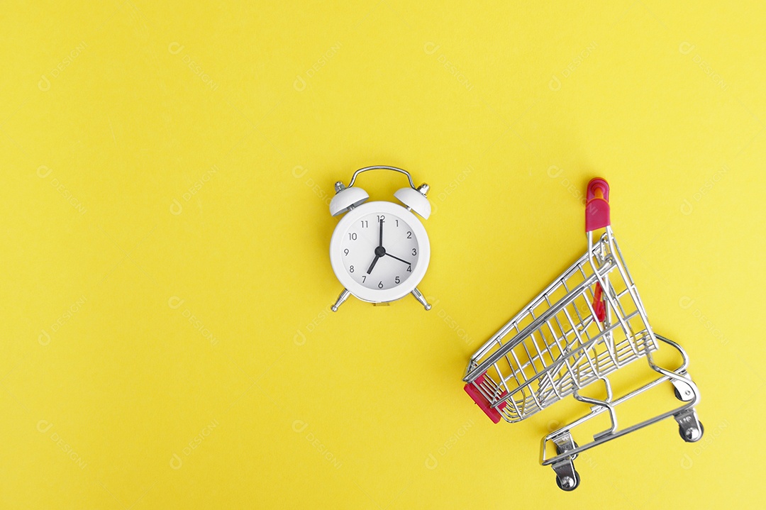 Carrinho de compra e relógio sobre fundo amarelo conceito de hora de fazer compra