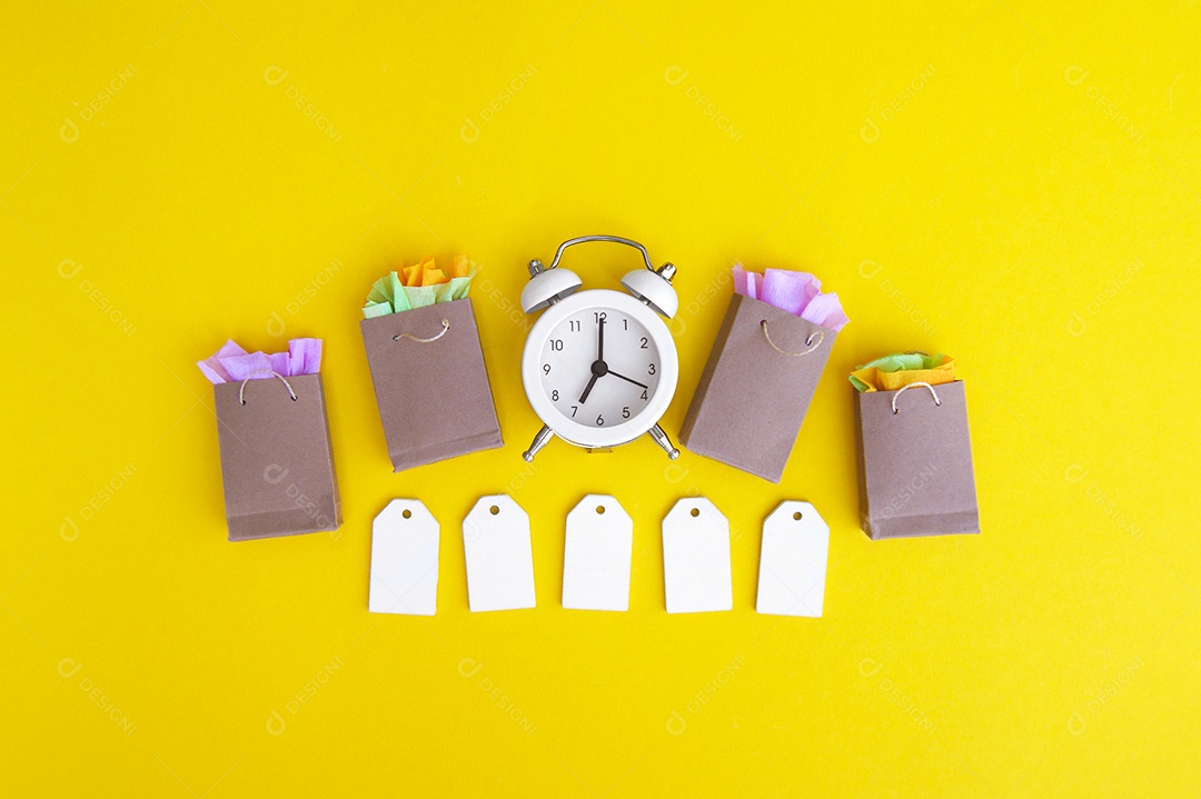 Etiquetas em branco sacos de papel e relógio branco conceito de hora de compras