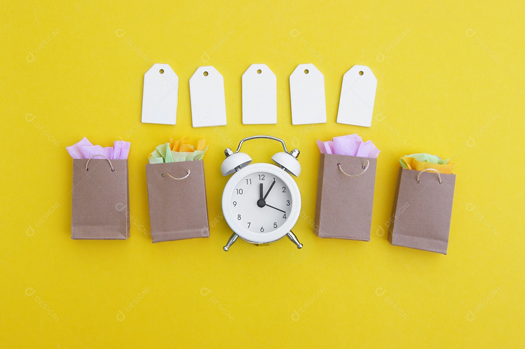 Etiquetas em branco sacos de papel e relógio branco conceito de hora de compras