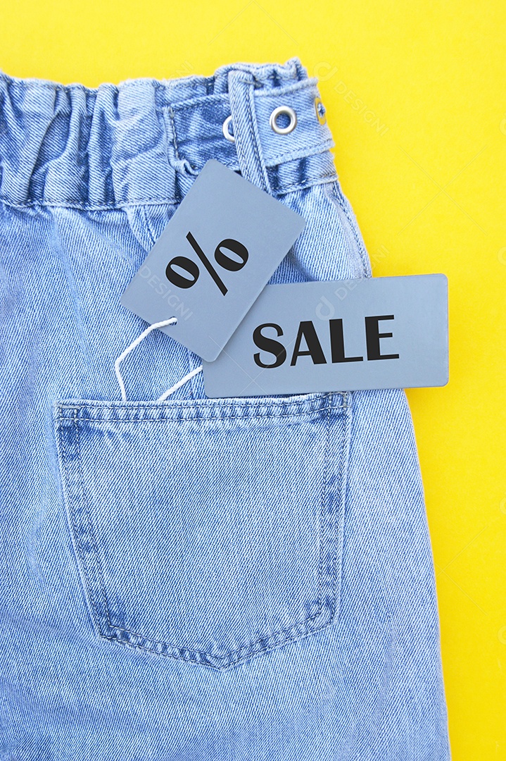 Jeans etiquetado como promoção conceito de compras sobre fundo amarelo