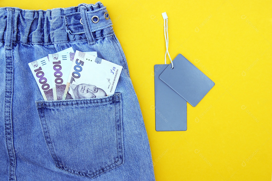 Parte de trás de uma peça jeans bonita com dinheiro no bolso e etiquetas ao lado