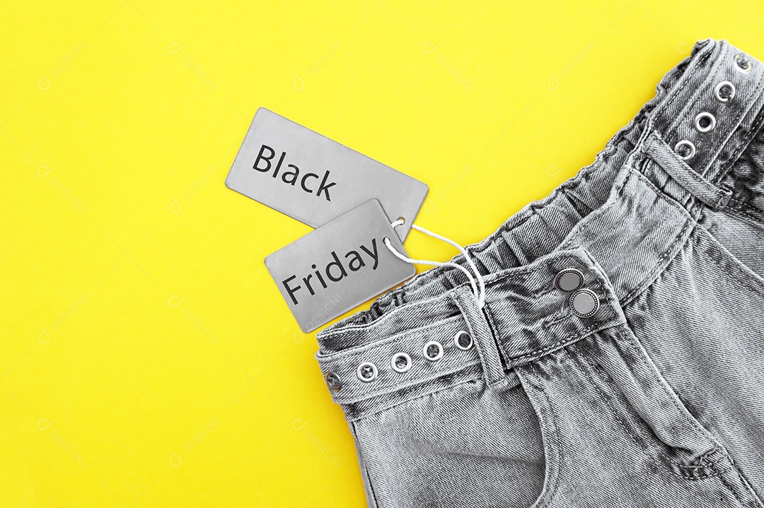 Roupa jeans com etiqueta de promoção sobre fundo amarelo