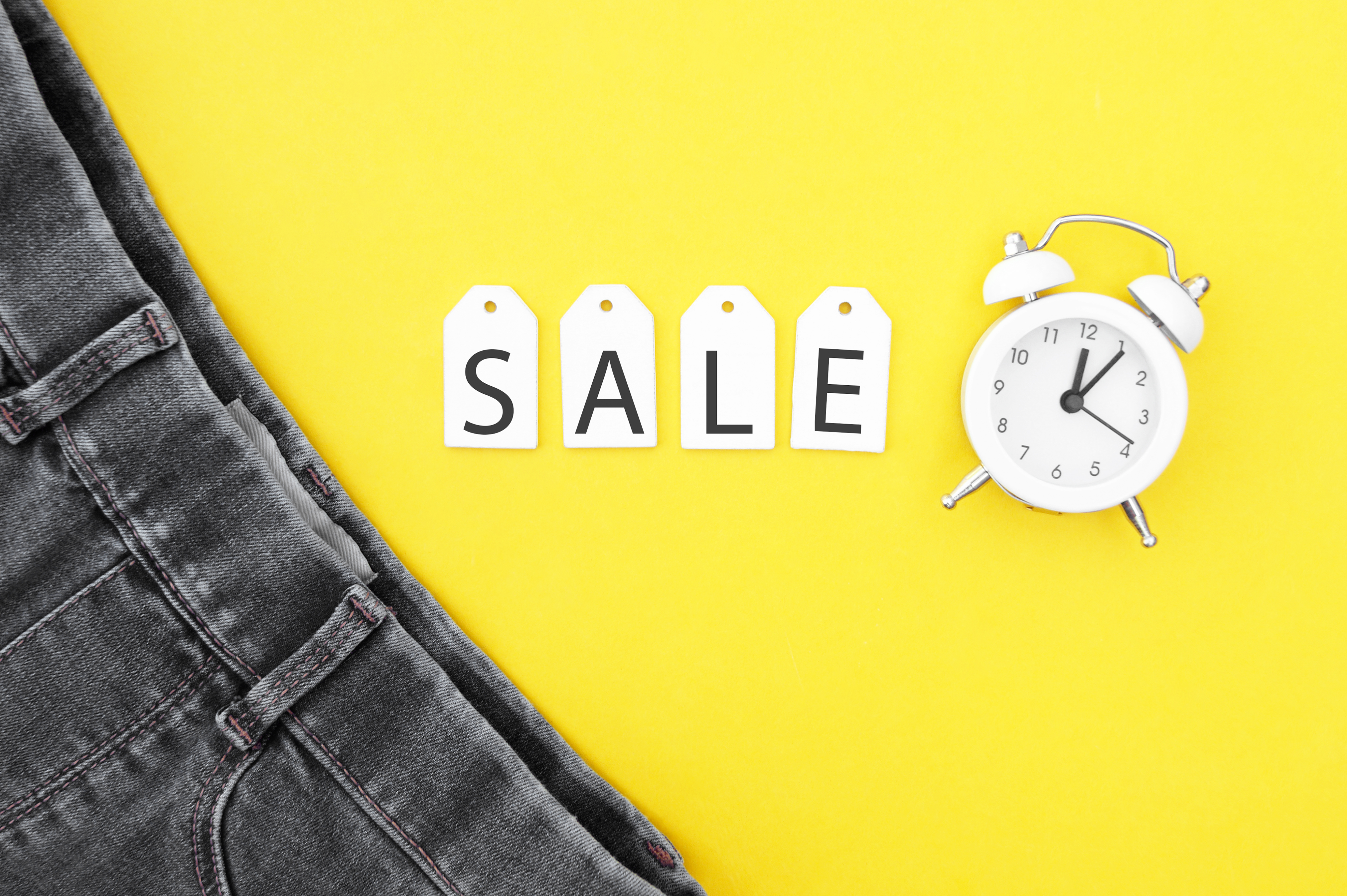 Peça jeans a venda com desconto sobre fundo amarelo