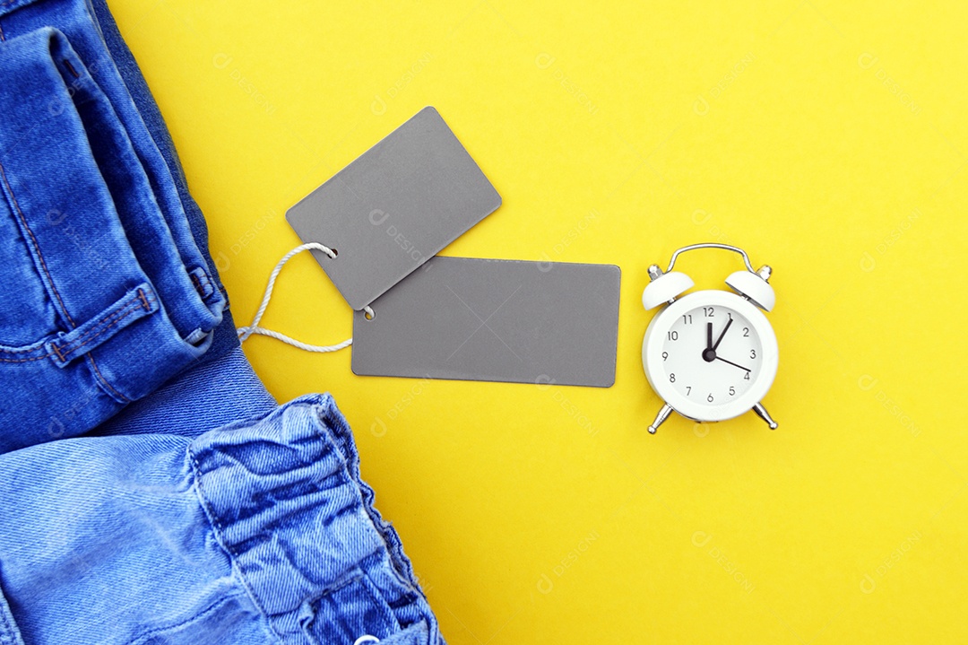 Detalhe de jeans etiquetas cinza em fundo amarelo conceito de compras e descontos