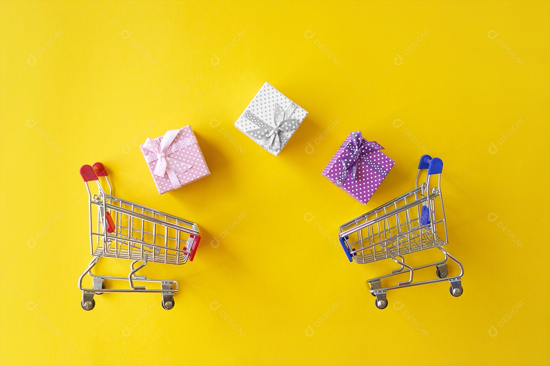 Presentes e carrinhos de compras sobre fundo amarelo