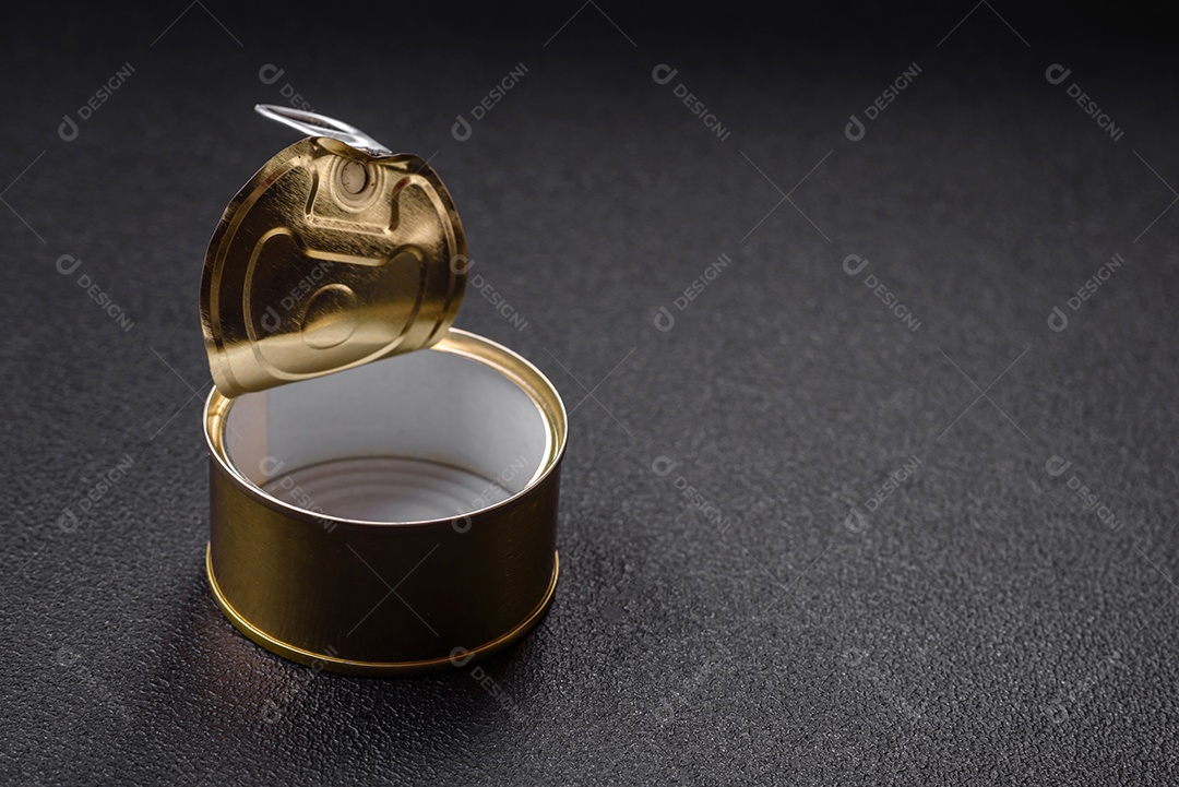 Lata redonda vazia de metal sem rolha para carne ou peixe enlatado sobre um fundo escuro de concreto