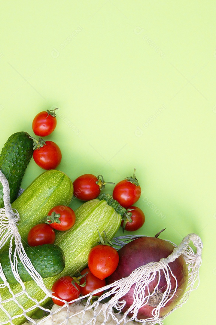 Sacola de barbante cheia de verduras legumes e frutas sobre fundo verde