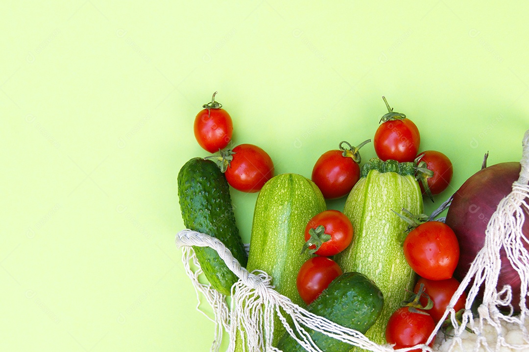 Sacola de barbante cheia de verduras legumes e frutas sobre fundo verde