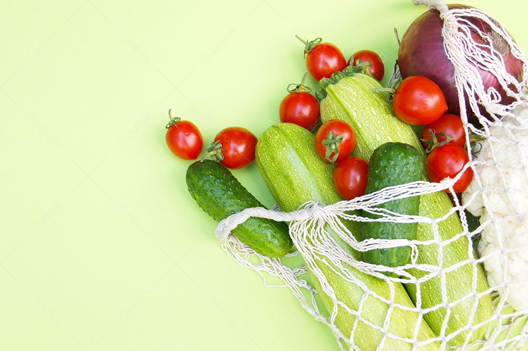 Abobrinha verde cebola roxa couve-flor tomates pepino em um saco de barbante