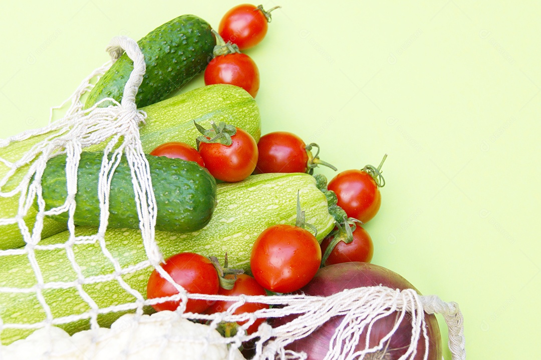 Pepinos verde tomates vermelhos abobrinha verde couve-flor e cebola em saco barbante