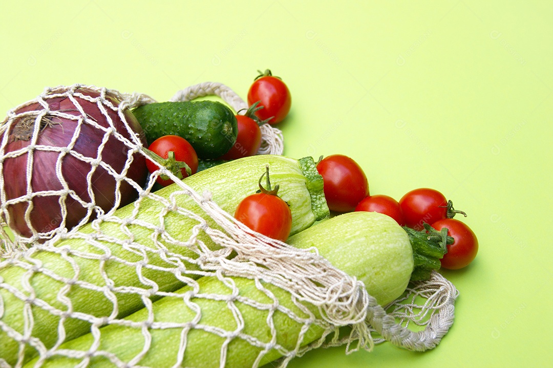 Tomates maduros pepinos verdes e abobrinha em um saco de barbante