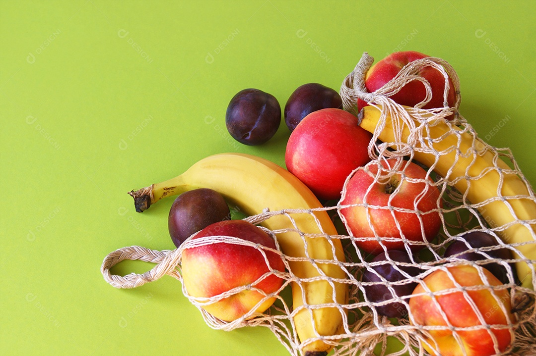 Frutas frescas espalhadas sobre fundo verde