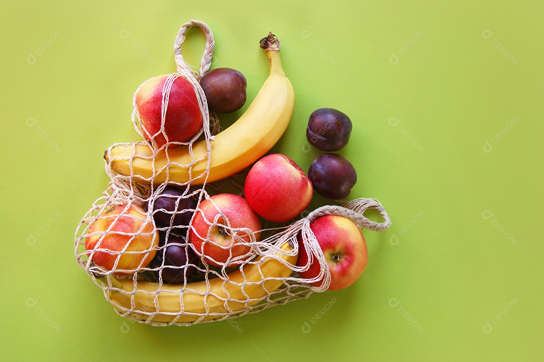 Frutas dentro de saco de barbante sobre fundo verde