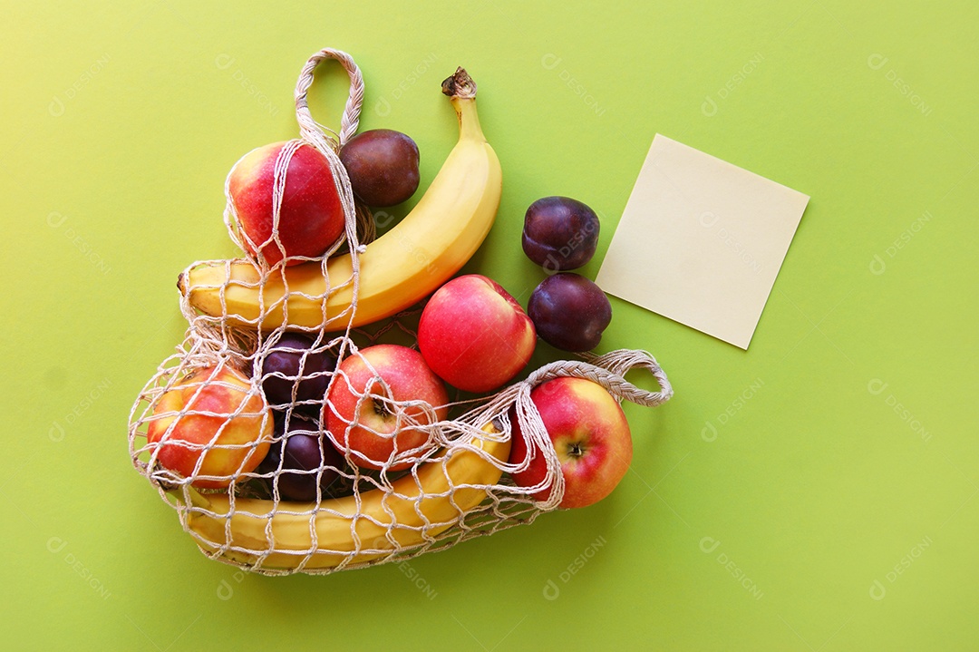 Frutas em saco de barbante e papel ao lado