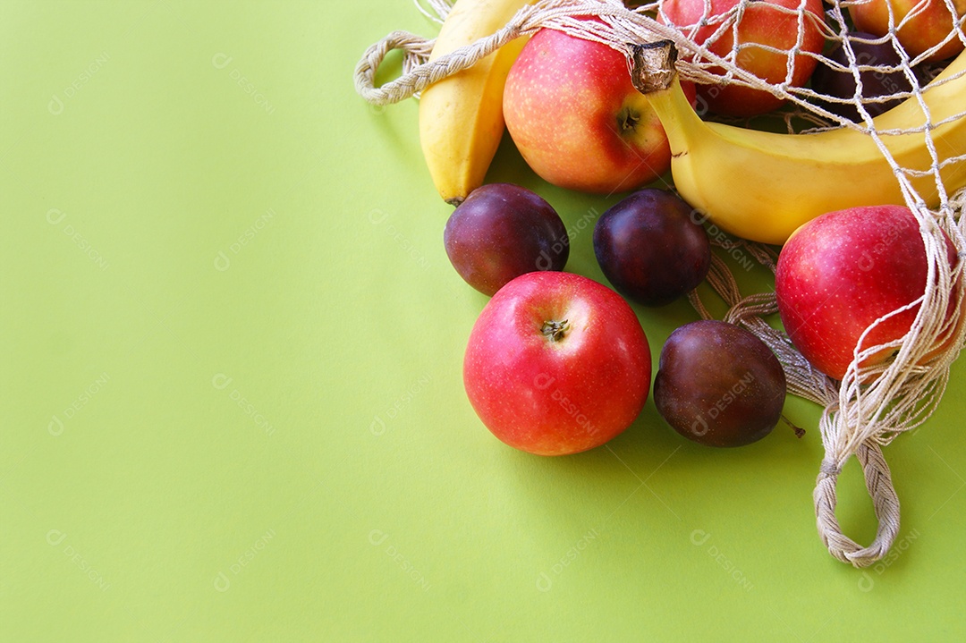 Frutas frescas espalhadas sobre fundo verde