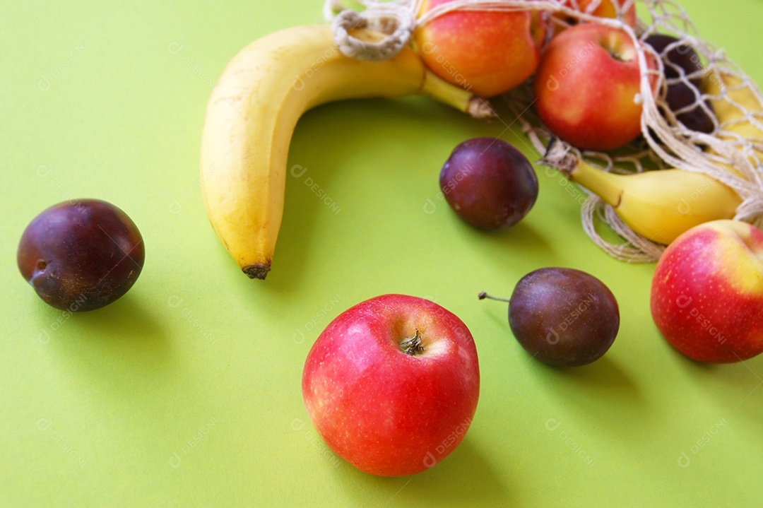 Frutas suculentas espalhadas sobre fundo verde