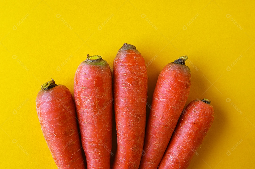 Cenouras naturais sobre fundo amarelo