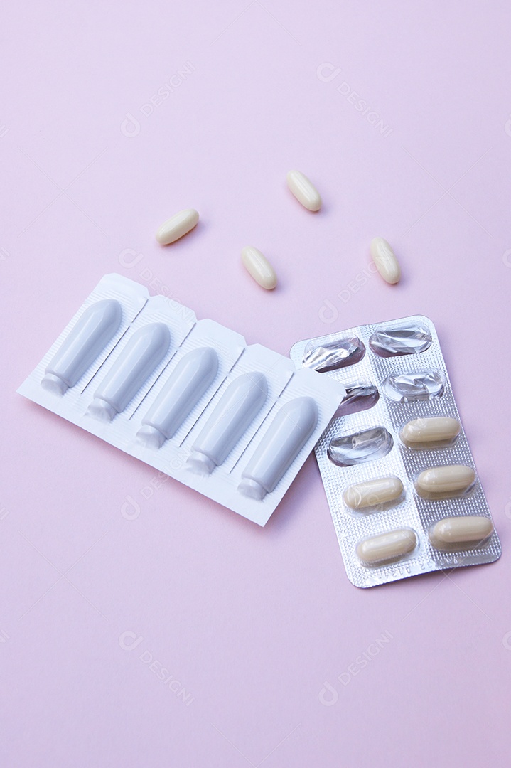 Comprimidos e supositório sobre fundo rosa