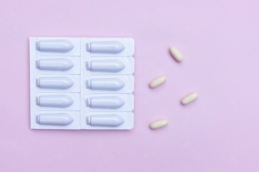 Supositórios e comprimidos sobre fundo rosa