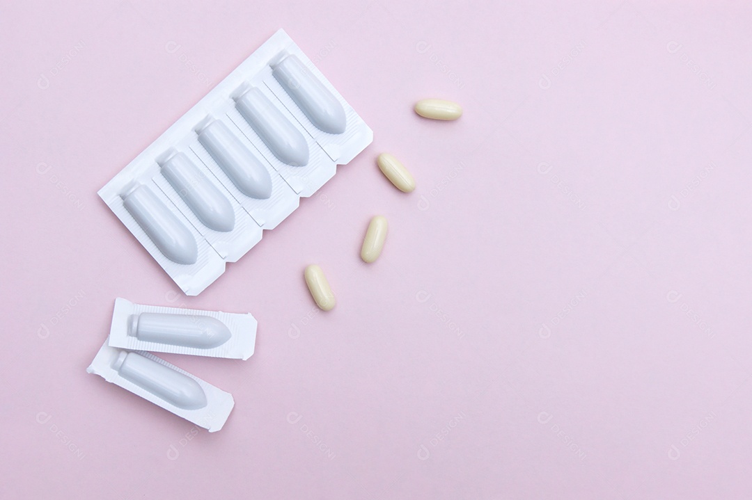 Supositórios e comprimidos sobre fundo rosa