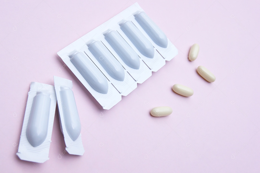 Supositórios e comprimidos sobre fundo rosa