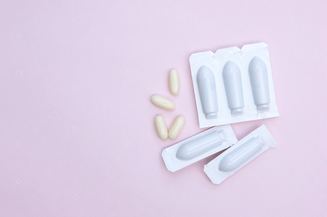 Comprimidos e supositório sobre fundo rosa