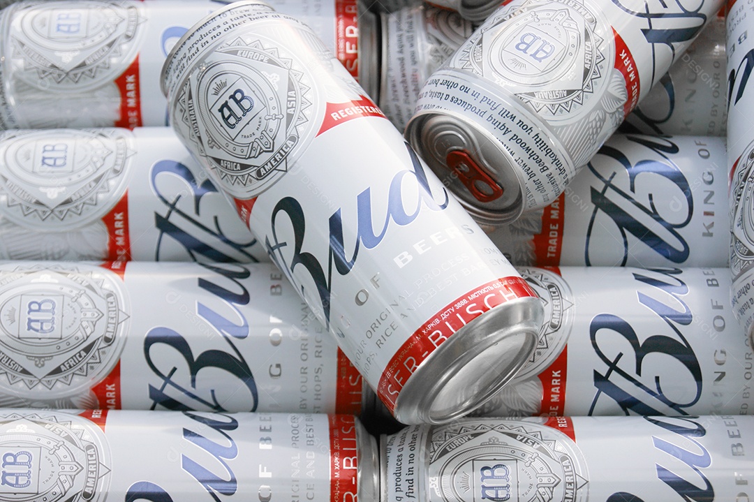 Várias latas de Budweiser juntas sobre fundo marrom