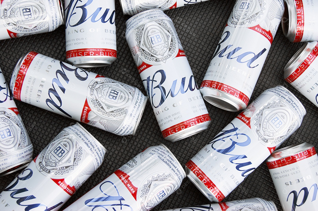 Várias latas de Budweiser juntas sobre fundo marrom