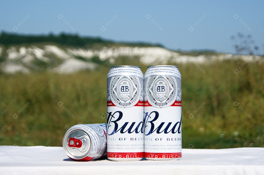 Três latas de Budweiser com fundo de natureza