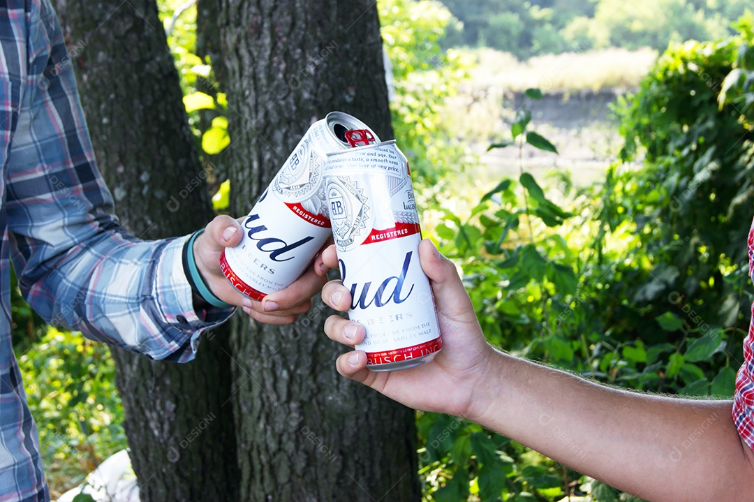 Dois homens tomando cerveja Budweiser sobre fundo de natureza
